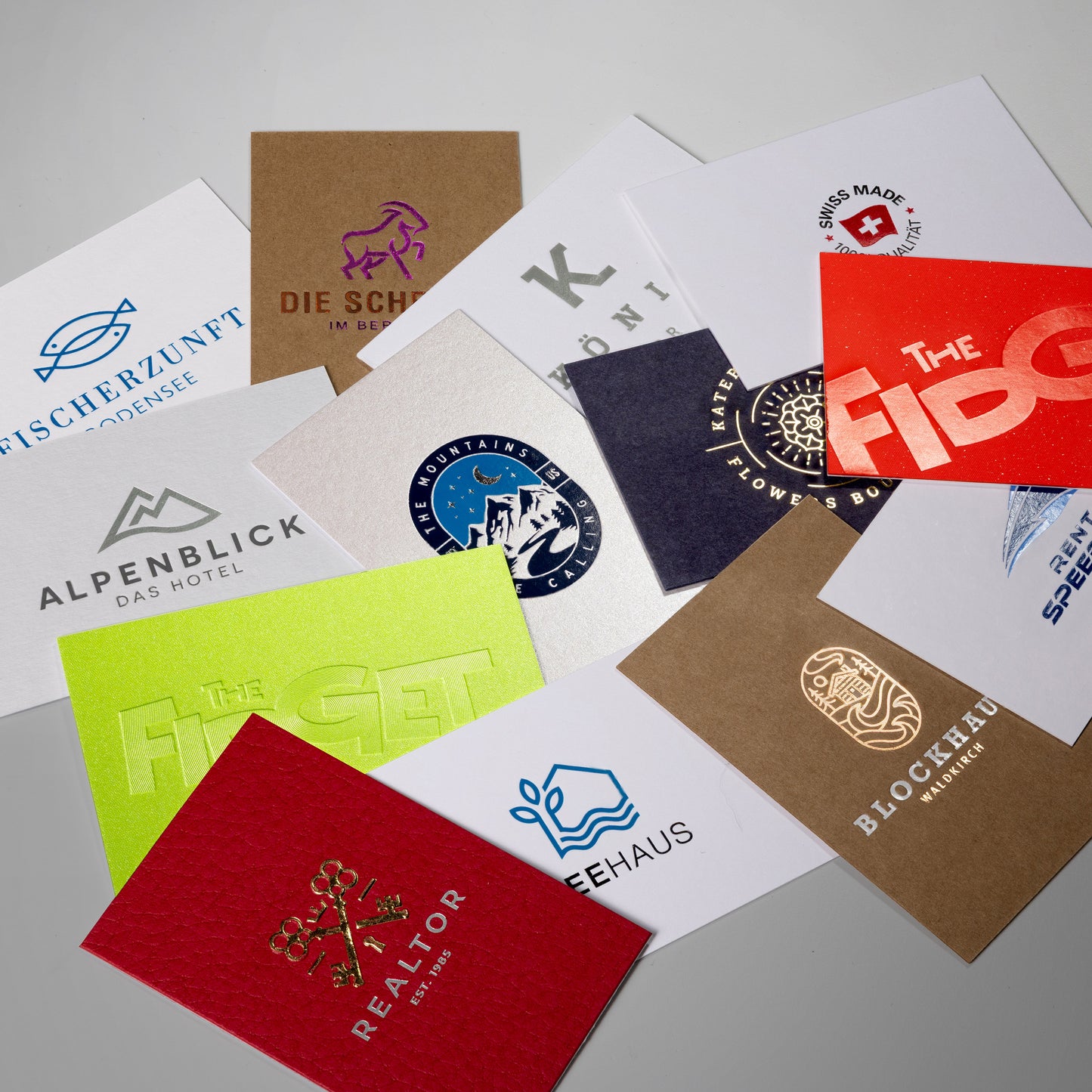 Mustersammlung diverser Visitenkarten, verschiedenfarbige Kartons und Prägetechniken der Papierveredelung.