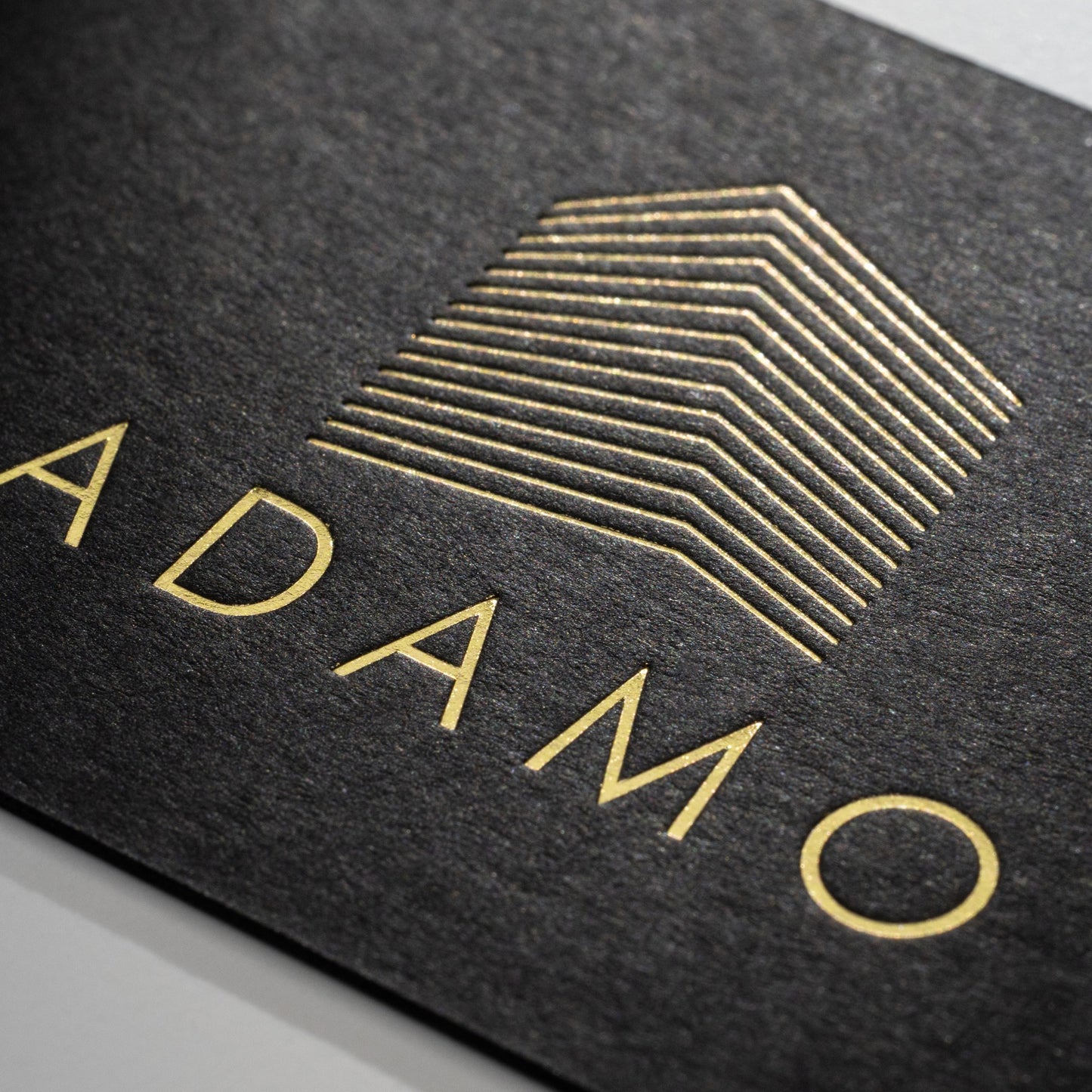 Schwarze Visitenkarte mit Heißfolienprägung: Beispiel ADAMO