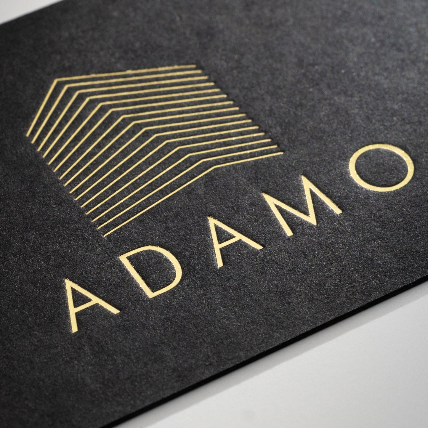 Schwarze Visitenkarte mit Heißfolienprägung: Beispiel ADAMO