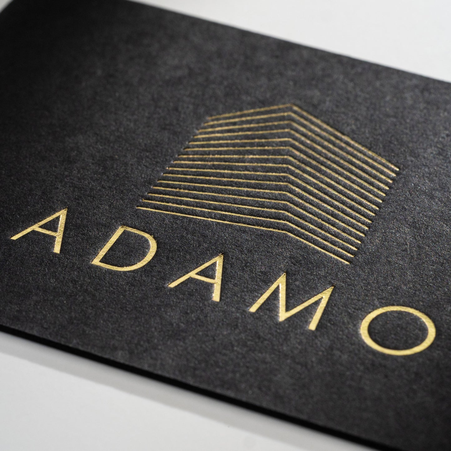 Schwarze Visitenkarte mit Heißfolienprägung: Beispiel ADAMO
